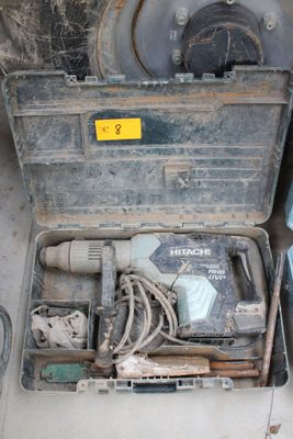 une boîte à outils contenant des outils, posée sur le sol