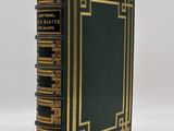 a black and gold book sitting on top of a white surface