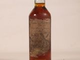 an old bottle of whiskey sitting on top of a white surface