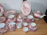 a lot of red and white plates and cups on a table