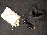 two black and white bags on a black surface with a white drawstring