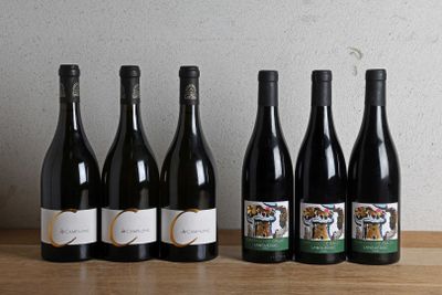 six bottles of wine are lined up on a wooden table