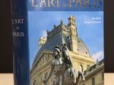 the book is sitting on a table in front of a building