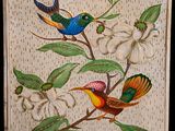 deux oiseaux perchés sur une branche d'arbre, à côté d'une fleur blanche