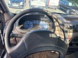 a steering wheel and dashboard of a car in a parking lot
