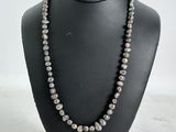 a black and white pearl necklace on a black mannequin