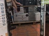 un homme debout à côté d'un micro-ondes posé sur une palette
