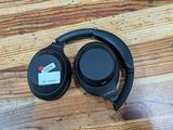 the headphones are sitting on a wooden table with a price tag