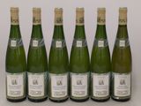 six bouteilles de vin sont alignées sur une table