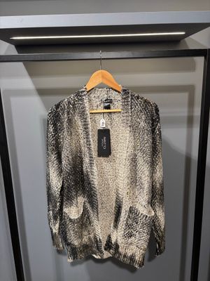 un pull noir et blanc suspendu à un cintre dans une armoire