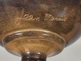 a brown vase with writing on it sitting on a table
