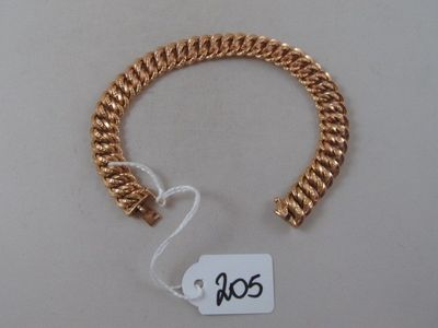 a close up of a gold bracelet with a tag on it