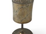 an antique silver cup with a floral design on the rim