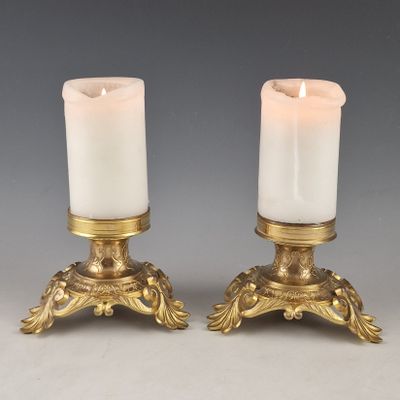 pair of antique brass candle holders with white candles