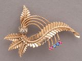 a gold brooch with colorful stones on it