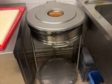 a trash can in the corner of a kitchen next to a sink
