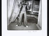 black and white photograph of a man standing in front of a curtain