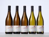 four bottles of wine are lined up on a table