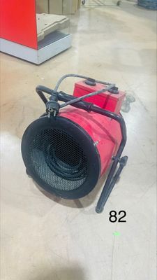un ventilateur rouge posé par terre dans un magasin