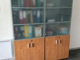 a glass cabinet in the corner of a room