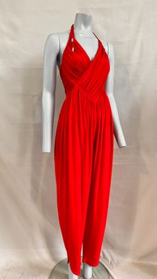 a red dress on a mannequin stand against a white backdrop