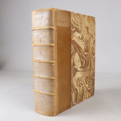 an old book sitting on top of a white table next to a white wall