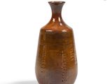 a brown vase that is sitting on a white surface