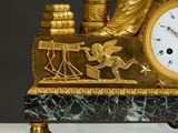 a gold clock sitting on top of a marble table