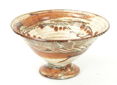 a brown and white bowl sitting on a white surface
