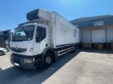 a white truck parked in a parking lot near a building