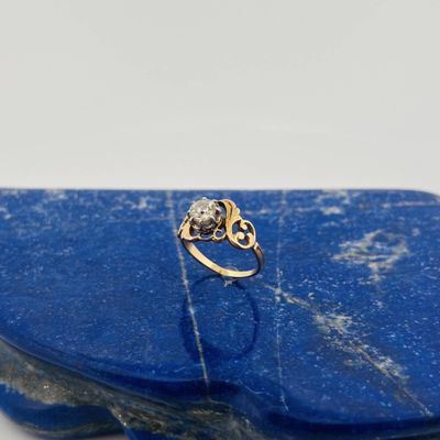 an image of a gold and diamond ring on a blue stone