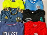 Plusieurs maillots de foot sont alignés sur une table