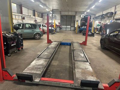 une voiture sur laquelle un mécanicien travaille dans le garage