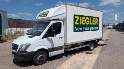 un camion de livraison blanc garé sur un parking