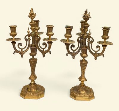 pair of antique brass candelabs on pedestals on a white background