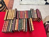 several old books are stacked on a red table in a room