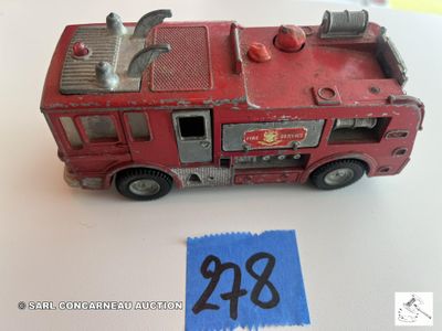 un petit camion de pompiers rouge sur lequel est collée une étiquette de prix