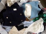 a suitcase full of clothes and a hat on the bed
