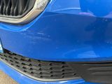 the front bumper of a blue car with a black grille