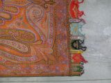 an orange and red paisley scarf on a white wall