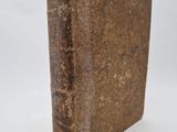 an old book sitting on top of a white surface
