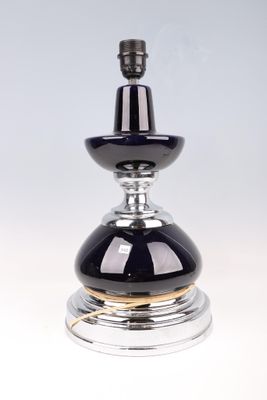 une photo d'un flacon de parfum en verre argenté et noir posé sur une surface transparente