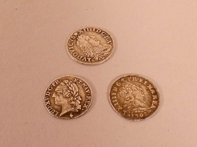 three different types of coins are shown on a white surface