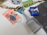 a cat toy, a brush, a litter bag, and other items on a table
