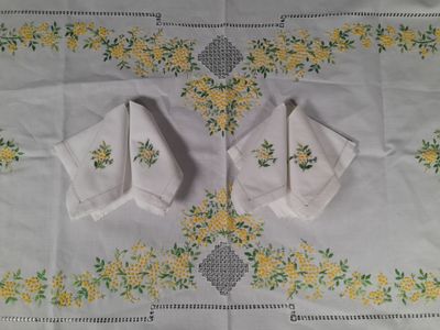 two napkins on a table with yellow flowers on them