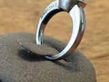 a silver ring sitting on top of a black stone
