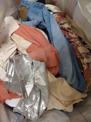 a pile of clothes sitting on a bed in a room