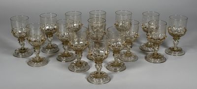 huit verres à vin sont alignés sur une surface blanche