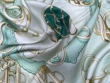 a picture of a green and white scarf with a gold and blue design