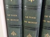 Plusieurs livres verts sont empilés sur une étagère dans une bibliothèque
